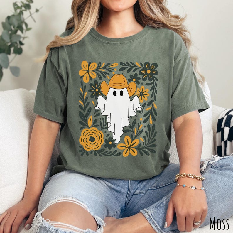 Moss Comfort Colors t-shirt featuring a cute ghost wearing a cowboy hat, surrounded by yellow and green floral designs—perfect for fall, Halloween, and western style lovers.