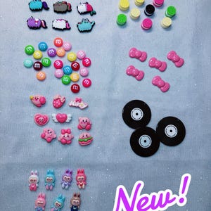 May include: A collection of colorful charms, including cartoon characters, candies, bows, and vinyl records. The image includes the text "3. Choose your charms" and "New!" on a light blue background.