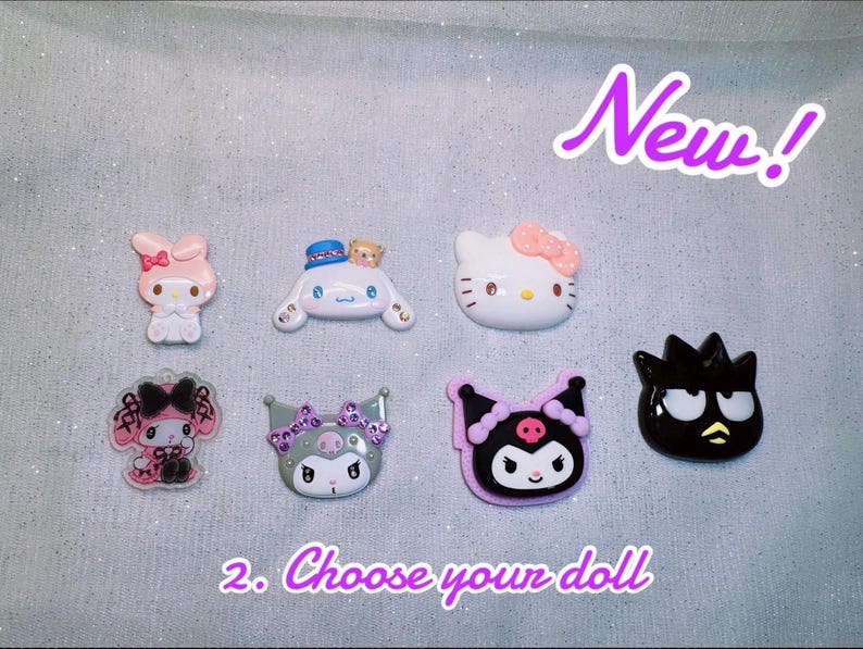 May include: A collection of seven colorful character dolls, including a pink bunny, a white cat with a pink bow, and a black character with yellow accents. The text "New!" and "2. Choose your doll" are also visible.