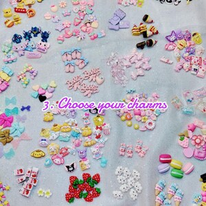 May include: A collection of colorful resin charms in various shapes, including bows, hearts, stars, and cartoon characters. The charms are in shades of pink, blue, yellow, and white. Text in the image reads "3. Choose your charms."