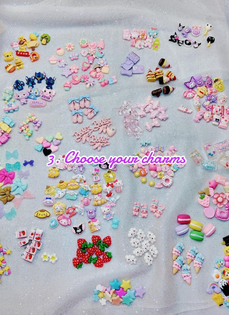 May include: A collection of colorful resin charms in various shapes, including bows, hearts, stars, and cartoon characters. The charms are in shades of pink, blue, yellow, and white. Text in the image reads "3. Choose your charms."