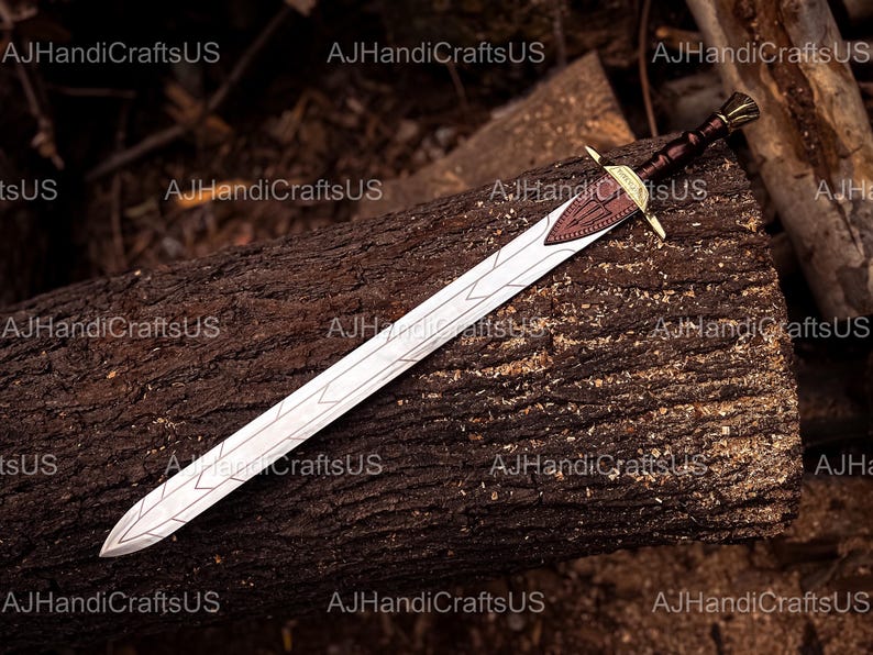 May include: A decorative sword with a silver blade and a brown leather-wrapped handle. The sword features a gold-colored crossguard and a brown leather accent on the hilt. The sword is resting on a dark brown log.