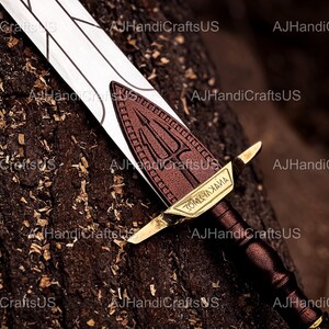 May include: A decorative sword with a white blade and a brown handle. The hilt features a brown emblem with a trident design and gold accents. The text "ZOMYAXAIMA" is visible on the hilt.