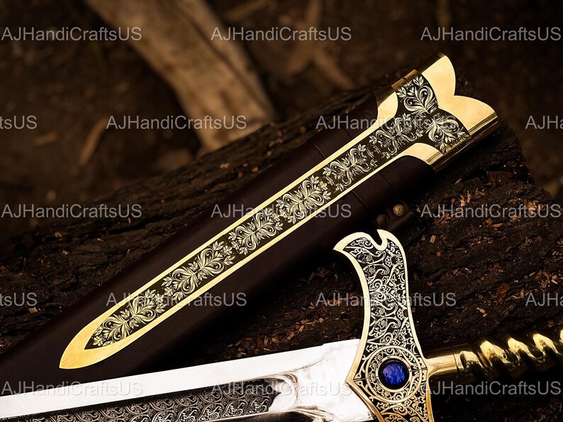 May include: A decorative sword with a gold-colored hilt and blade, featuring intricate floral patterns. The sword's handle has a blue gem. The scabbard is dark brown. The sword is displayed on a dark, textured surface.