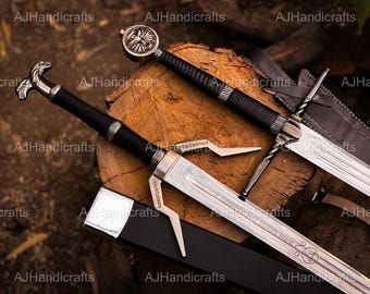May include: Two decorative swords with black handles and silver blades rest on a wooden surface. One sword has a circular pommel, while the other features a stylized dragon head. The blades are engraved with text.
