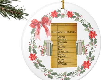 May include: A white ceramic Christmas ornament with a gold string, featuring a festive design. The ornament has a wreath of red poinsettias, holly, and a red bow. A library card design reads "Our Book Club 2025" with a list of names.
