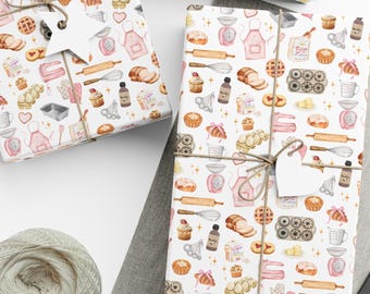Op de afbeelding: Drie ingepakte cadeaus met wit papier met een aquarelpatroon van bakgereedschap en gebak. De cadeaus zijn vastgebonden met touw en hebben blanco labels. Een bol touw, een schaar en blanco labels zijn ook zichtbaar.