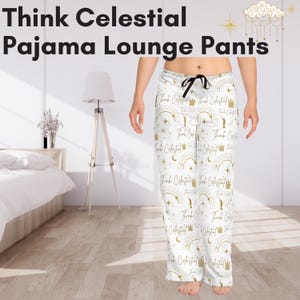 Könnte beinhalten: Weiße Schlafanzug-Loungehosen mit einem goldenen Druck von Sternen, Monden, Kronen und dem Text "Think Celestial".