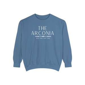 Pode incluir: Uma camisa de moletom azul com texto branco que diz "THE ARCONIA NEW YORK, NEW YORK".