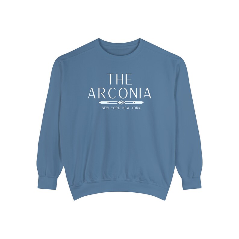 Pode incluir: Uma camisa de moletom azul com texto branco que diz "THE ARCONIA NEW YORK, NEW YORK".