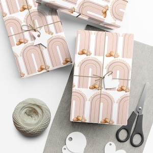 May include: A set of four gift wrap sheets with a white background and a repeating pattern of brown and pink arches with the text "What excellent boiled potatoes" printed on each sheet.