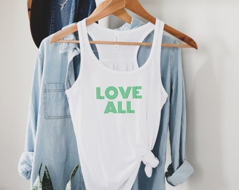 May include: White tank top with a green graphic that says "LOVE ALL" in a retro font.