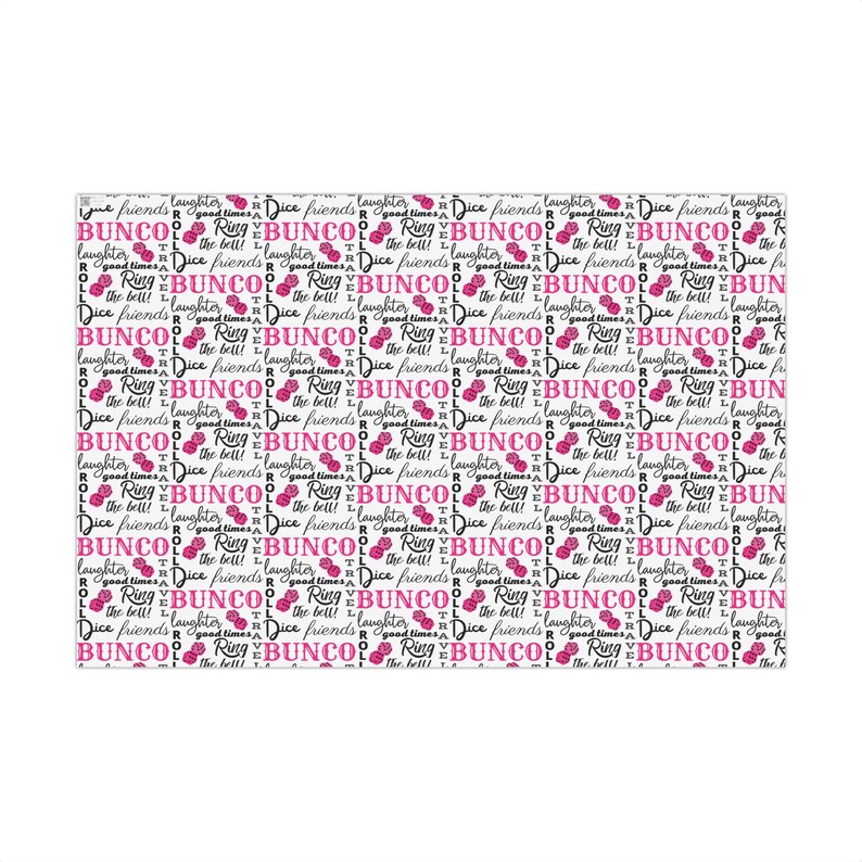 May include: Pink and black dice-themed wrapping paper. The design features repeating patterns of dice, the words 'BUNCO', 'ROLL', 'Ring the bell!', 'Dice friends', 'laughter', and 'good times'.  The paper is shown wrapped around several gift boxes.  The text is bold and stylish. The pink dice are a vibrant shade against the white background.