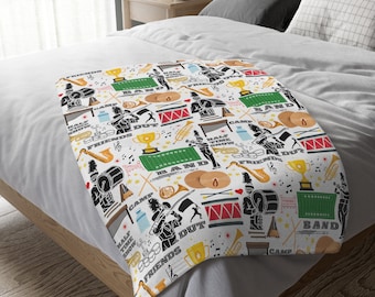 Può includere: Coperta bianca con un motivo colorato a tema banda musicale. Il motivo include strumenti musicali, tamburi, bandiere e le parole "Camp", "Band", "Friends" e "Half Time Show".