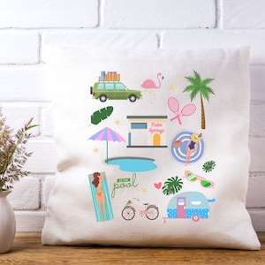 May include: A white pillow with a colorful illustration of a summer vacation scene. The illustration includes a car, a flamingo, a palm tree, a pool, a beach umbrella, a camper, a bicycle, sunglasses, and a sign that says "Palm Springs".