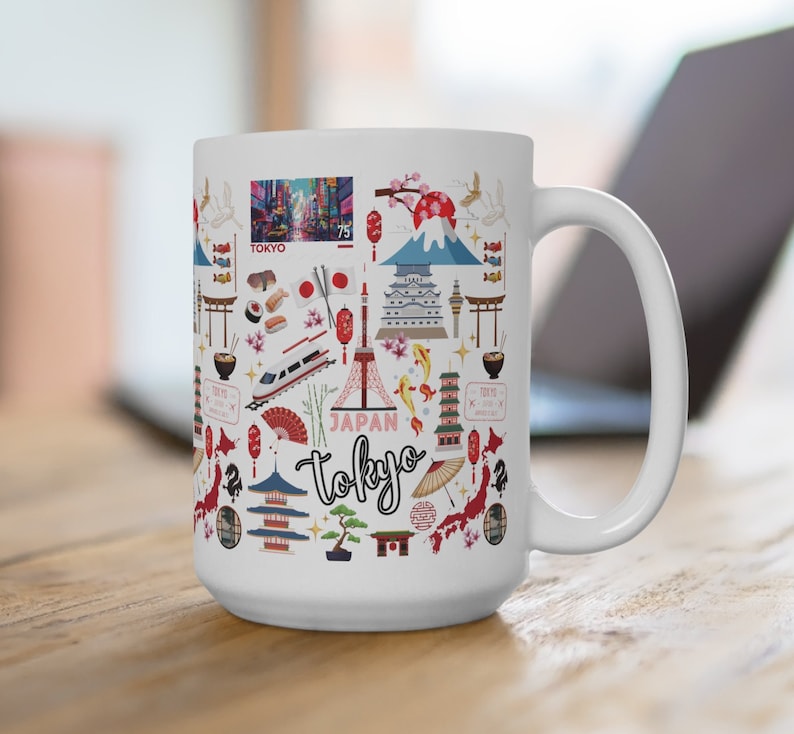 May include: White ceramic mug with a colorful design featuring Japanese landmarks, including Mount Fuji, the Tokyo Skytree, and a red torii gate. The mug also features a red and white Japanese flag, cherry blossoms, and the text "Japan Tokyo".