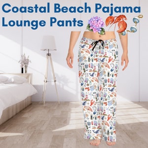 May include: White pajama pants with a coastal beach theme print. The print features seashells, lighthouses, anchors, lobsters, and beach umbrellas.  "Coastal Beach Pajama Lounge Pants" is written at the top of the image.