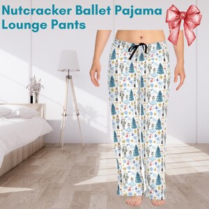 May include: White pajama pants with a Nutcracker Ballet print. The print features a repeating pattern of Nutcracker soldiers, ballerinas, Christmas trees, and other holiday symbols. The pants have a drawstring waistband.