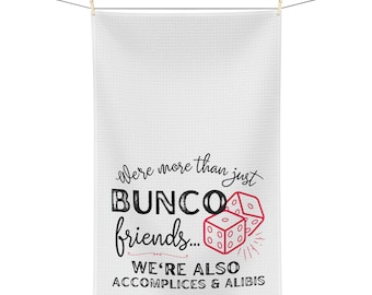 Peut inclure: Serviette de cuisine blanche avec du texte noir qui dit "We're more than just BUNC0 friends... WE'RE ALSO ACCOMPLICES & ALIBIS". Il y a deux dés rouges avec des points blancs sur la serviette.