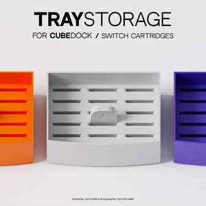 May include: Three rectangular storage trays in orange, white, and purple, each featuring horizontal slots and a central tab with a triangle icon. The text TRAYSTORAGE FOR CUBEDOCK / SWITCH CARTRIDGES is printed above the trays.