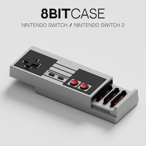 Puede incluir: Una funda gris de 8 bits para Nintendo Switch y Nintendo Switch 2. La funda está diseñada para parecerse a un mando de videojuegos clásico, con detalles en negro y rojo. El texto "8BITCASE" está en la parte superior.