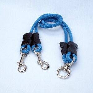 Puede incluir: Una correa doble para perros azul con mangos de goma negra y clips plateados.