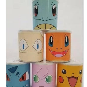 May include: Six colourful metal canisters with different Pokemon characters on them. The canisters are stacked in a pyramid shape. The characters are Squirtle, Bulbasaur, Charmander, Pikachu, Jigglypuff, and Blastoise.