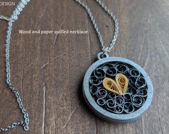 Collar con forma de corazón amarillo, realizado con la técnica de filigrana de papel, y enmarcado en madera.