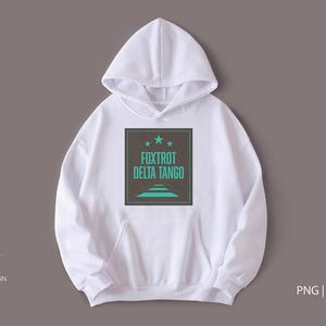Peut inclure: Sweat-shirt à capuche blanc avec un graphique carré noir qui dit "Foxtrot Delta Tango" en texte turquoise avec trois étoiles au-dessus du texte.