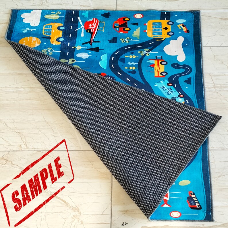 May include: A blue and yellow play mat with a road and various vehicles, including a helicopter, a school bus, and a car. The mat has a non-slip backing.