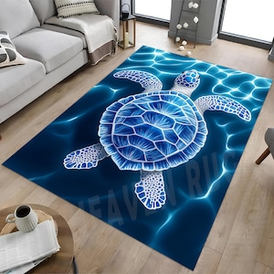 Puede incluir: Una alfombra rectangular con un diseño de tortuga marina azul. La tortuga está representada en tonos azules y blancos, con un patrón de caparazón detallado. El fondo imita el agua con reflejos azul claro.