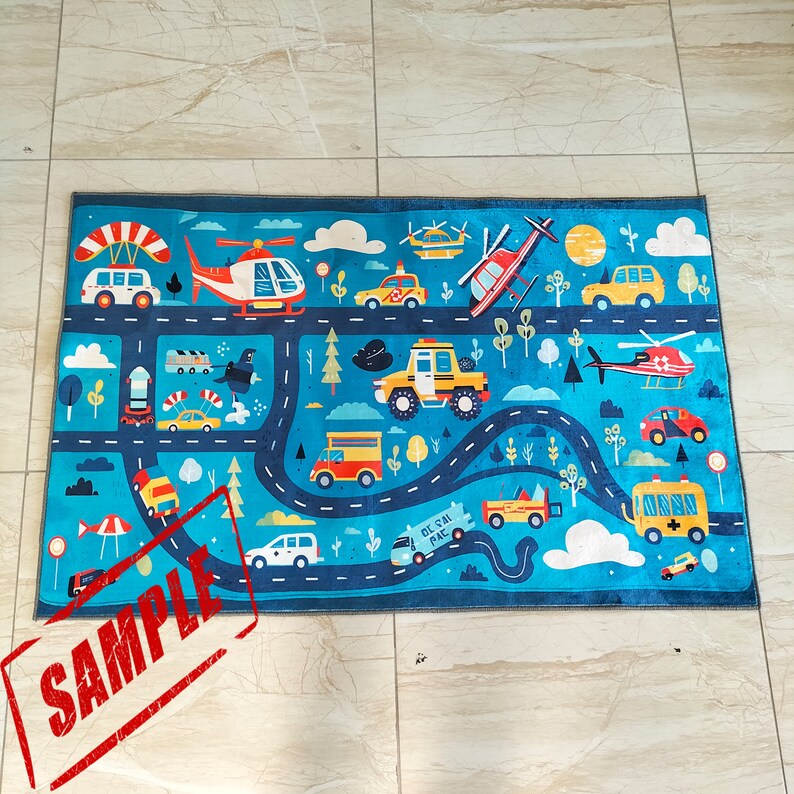 May include: A blue and white play rug with a road and various vehicles, including cars, trucks, helicopters, and airplanes. The rug features a blue background with white roads and a variety of colorful vehicles. The text "On the Road" is printed on the rug.