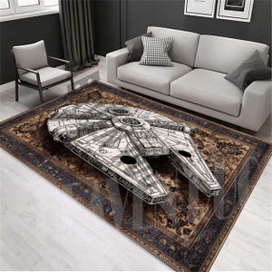 Może przedstawiać: Brązowy i niebieski dywan z vintage'owym wzorem przedstawia czarno-białą ilustrację statku kosmicznego Millennium Falcon z Gwiezdnych Wojen.