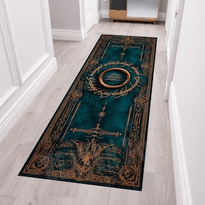 May include: A rectangular runner rug featuring a deep teal background with intricate gold-colored filigree patterns and a central circular ring motif surrounded by stylized elvish script, creating a detailed and ornate decorative floor covering.