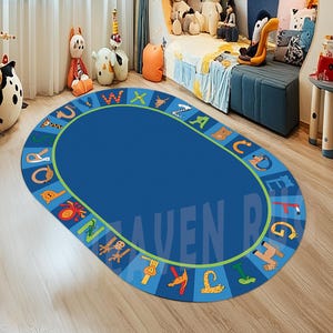 May include: A blue oval-shaped alphabet rug with a green border and colorful animal illustrations surrounding the letters. The rug is on a wooden floor in a room with a bed and stuffed animals.