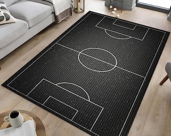 May include: Black and white area rug with a football pitch design. The rug has a grid pattern and white lines outlining the pitch, including the centre circle, penalty areas, and goal boxes.