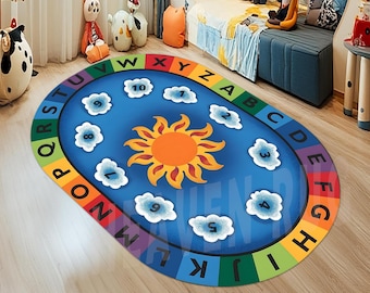 May include: A blue oval-shaped play rug with a yellow sun in the center. The rug has a rainbow border with the alphabet and numbers around the edge.