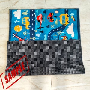 May include: A colorful play mat with a road, cars, a helicopter, and clouds. The mat has a gray non-slip backing.