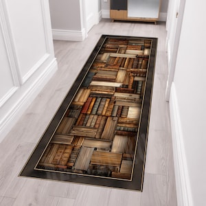 May include: A rectangular runner rug featuring a detailed print of stacked vintage books in various shades of brown, tan, and grey. The rug has a solid dark border framing the central pattern of horizontal and vertical book spines and covers.