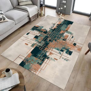 May include: A rectangular area rug with an abstract design. The rug features a cream-colored background with a geometric pattern in teal, copper, and light blue. The design includes intersecting lines and brushstroke-like shapes.