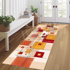 May include: A rectangular hallway rug with a geometric design. The rug features squares and rectangles in shades of red, orange, yellow, and beige, with black lines. The rug is placed on a wooden floor.