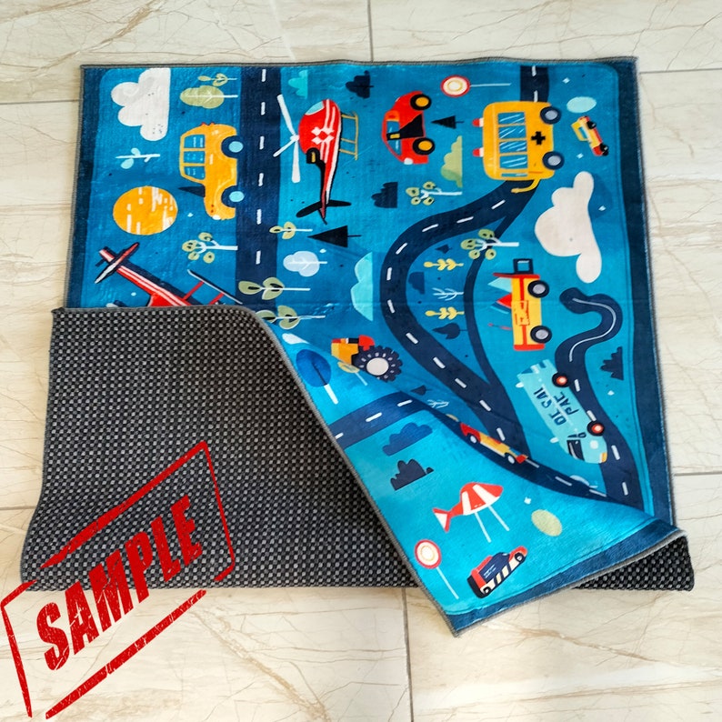 May include: A blue and gray play mat with a road and various vehicles printed on it. The mat has a non-slip backing.