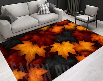 May include: A rectangular area rug featuring a pattern of large, stylized maple leaves in shades of red, orange, yellow, and black. The rug is placed in a living room setting, with a gray sofa and chair visible in the background. The rug's design evokes an autumn theme.