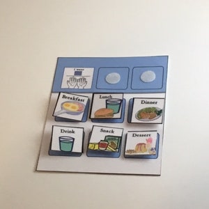 May include: A visual communication board with illustrated meal options. The board includes images for breakfast, lunch, dinner, drink, snack, and dessert. The top section has two blank circles and a section that says "I want" with hand gestures.