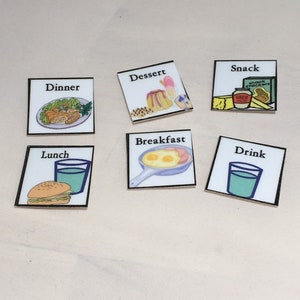 May include: A collection of six square cards with food illustrations. The cards are labeled "Dinner," "Dessert," "Snack," "Lunch," "Breakfast," and "Drink." Each card features a different food item, such as a burger, eggs, and a glass of water.