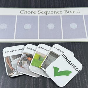 May include: A rectangular white chore sequence board with five light purple rectangular sections, each featuring a circular fastener. Below are five cards showing steps to make a bed, labeled 1 through 4, and a final card with a green checkmark and text FINISHED!