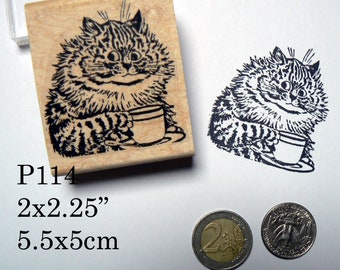 May include: A black and white rubber stamp of a cat holding a teacup. The stamp is on a wooden block with the text "P114 2x2.25" 5.5x5cm" printed below it.