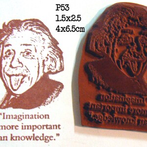 May include: A rubber stamp featuring a brown image of Albert Einstein sticking out his tongue. The stamp is labeled P53 and measures 1.5 x 2.5 inches. The quote "Imagination is more important than knowledge" is printed below the image.