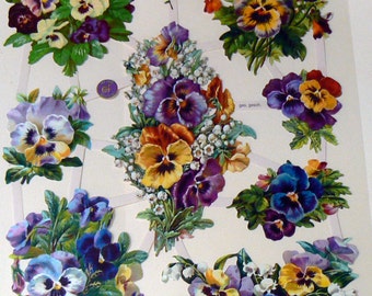 Puede incluir: Una hoja de pegatinas florales troqueladas con coloridas flores de pensamiento y otras flores. Los pensamientos son en tonos de morado, amarillo, azul y blanco, con hojas verdes. Algunas pegatinas están dispuestas en ramos.