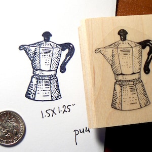 Puede incluir: Un sello de madera con una ilustración en blanco y negro de una cafetera. El sello mide 1,5 x 1,25 pulgadas.